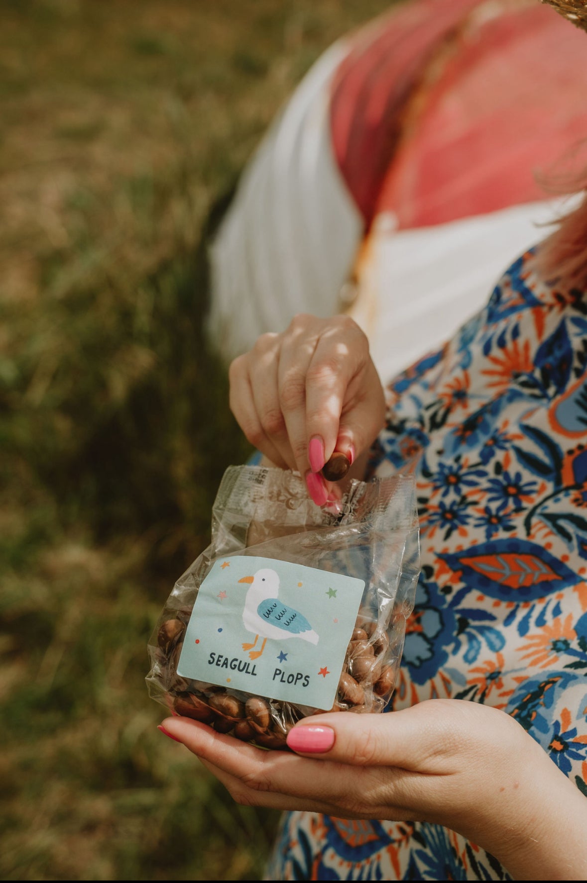 Person holding a package labelled 'Seagull Plops' in a natural setting.