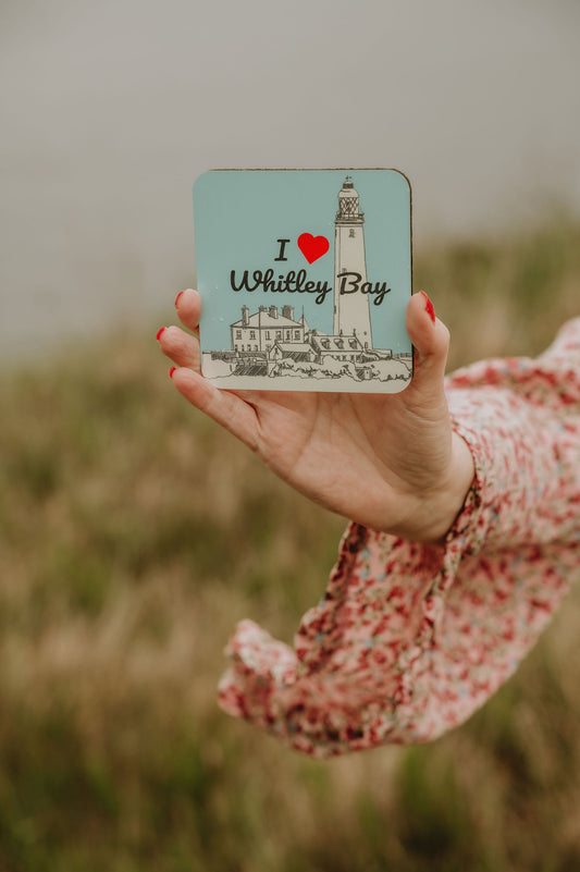 Coaster with 'I ❤️ Whitley Bay' design held by a person in a field