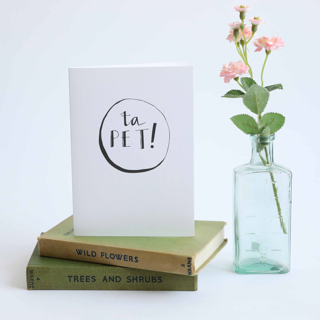 ta pet card next to vase with flowers